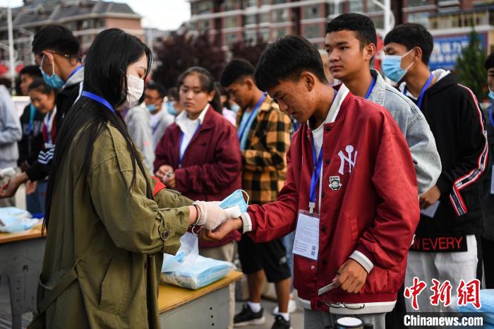 7月7日，考生在拉薩三高考點(diǎn)外測量體溫?！『闻罾?攝